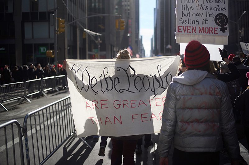 Protesters hold signs quoting the U.S. constitution