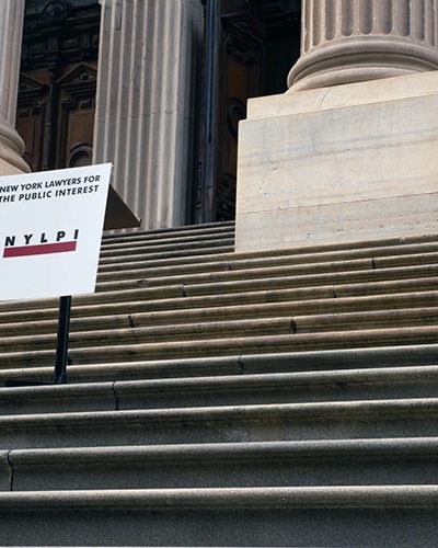 Image shows a NYLPI sign on the steps of New York's Tweed Courthouse in Lower Manhattan