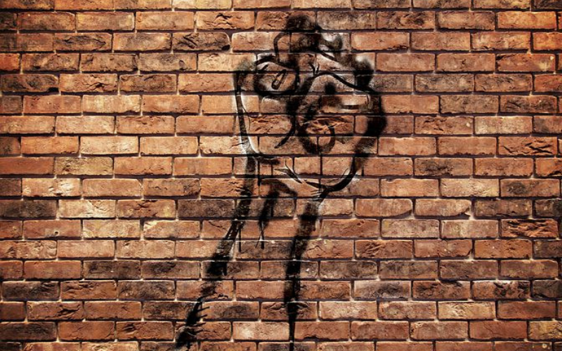 A powerful fist spray painted onto a brick wall.